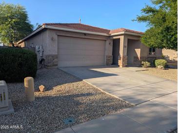 Charming home featuring a neutral color palette, a two-car garage, and a well-manicured desert landscape at 17328 W Pinnacle Vista Dr Dr, Surprise, AZ 85387
