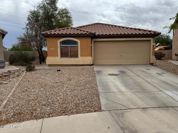 Single-story home featuring neutral stucco, a tile roof, gravel landscaping, and a two-car garage at 20761 N Herbert Ave, Maricopa, AZ 85138
