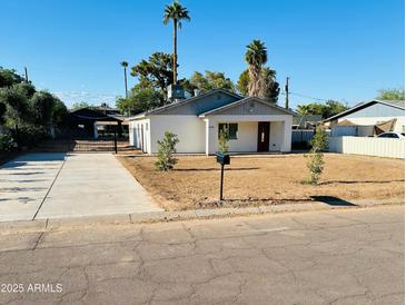 Charming single-story home with well-manicured lawn, palm trees, and a lovely entrance with fresh driveway at 2148 W Hayward Ave, Phoenix, AZ 85021