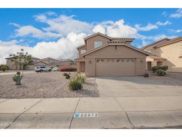 Two-story home featuring a neutral palette, large garage, and low-maintenance desert landscaping at 22672 W Solano Dr, Buckeye, AZ 85326