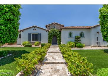 Inviting front entrance with stone walkway and lush landscaping leading to a charming white stucco home at 24372 N 96Th Ln, Peoria, AZ 85383