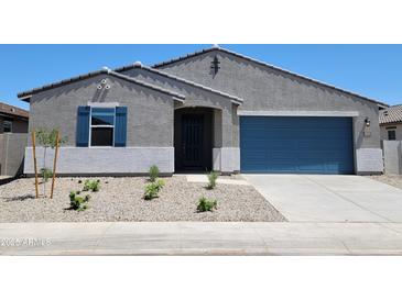 Charming single-story home with a blue garage door and desert landscaping in the front yard at 37172 W Parador Ln, Maricopa, AZ 85138