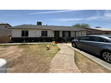 Charming single-story home with a quaint walkway and driveway parking at 4823 W Palm Ln, Phoenix, AZ 85035