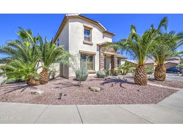 Charming two-story home featuring a well-maintained landscape and beautiful desert palm trees at 7419 S 25Th Dr, Phoenix, AZ 85041