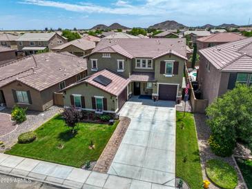 Two-story home with a well-manicured lawn, three-car garage, and solar panels in a quiet residential neighborhood at 761 W Desert Hollow Dr, San Tan Valley, AZ 85143