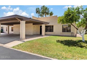 Charming single-story home with a covered carport and well-manicured front lawn at 7707 E Park View Dr, Mesa, AZ 85208