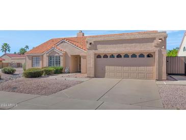 Charming single-story home featuring a well-manicured yard and attached two-car garage, set in a suburban neighborhood at 12730 N 90Th Way, Scottsdale, AZ 85260