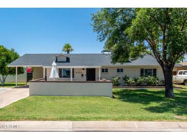 Charming single-story home featuring a well-manicured lawn, covered porch and stylish architectural details at 6302 N 13Th Pl, Phoenix, AZ 85014