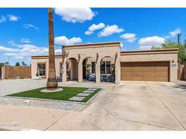 Charming single-story home featuring a stucco exterior, arched entry, and a well-maintained front yard at 858 W Knowles Cir, Mesa, AZ 85210
