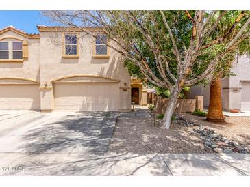Inviting two-story home featuring an attached two-car garage and desert landscaping at 8788 W Wood Dr, Peoria, AZ 85381