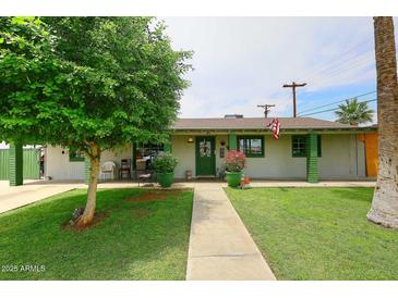 Charming single-story home with a well-manicured lawn and a quaint, inviting front porch at 2916 N 48Th Ave, Phoenix, AZ 85031