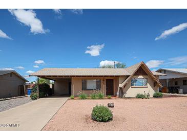 Charming single-story home with covered parking, a low maintenance yard, and beautiful blue skies above at 322 N Williams St, Mesa, AZ 85203