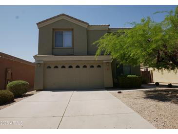 Two-story home featuring an attached two-car garage and easy-care desert landscaping for water conservation at 43241 W Kristal Ln, Maricopa, AZ 85138