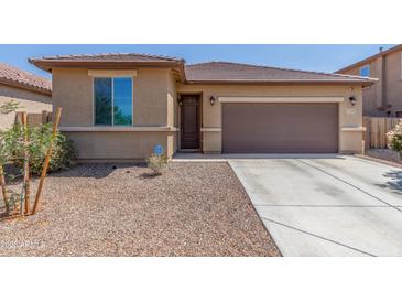Charming home featuring a brown garage door, desert landscaping, and a cozy front porch at 17296 W Molly Ln, Surprise, AZ 85387