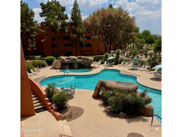 Resort-style pool with waterfalls and lounge seating offers a relaxing outdoor oasis at 4303 E Cactus Rd # 235, Phoenix, AZ 85032