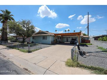 Charming single story home with a covered carport, mature landscaping, and a classic chain-link fence at 4323 W Rose Ln, Glendale, AZ 85301