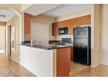 Functional kitchen features stone countertops, wood cabinets, and appliances at 10136 E Southern Ave # 1052, Mesa, AZ 85209