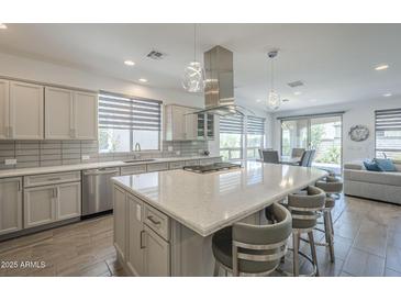 Modern kitchen with stainless steel appliances, a large center island, and stylish pendant lighting at 116 E Santa Lucia Ln, Queen Creek, AZ 85140