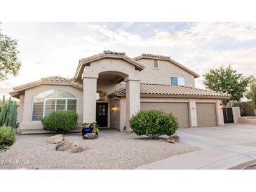 Inviting two-story home featuring a well-manicured yard and a welcoming arched entryway at 19276 N 90Th Pl, Scottsdale, AZ 85255