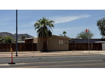 Exterior shot of home behind fence and palm tree on main street at 20626 N 35Th Ave, Glendale, AZ 85308