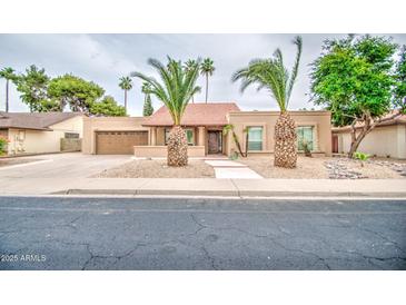 Charming single-story home with desert landscaping and a red tile roof, complemented by mature palm trees at 2329 W Keating Ave, Mesa, AZ 85202