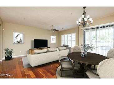 Spacious living room with an open floor plan and hardwood floors, including a chandelier over a dining table at 2989 N 44Th N St # 2007, Phoenix, AZ 85018