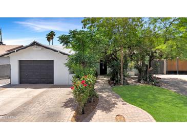 Charming single-story home features a brick driveway and walkway, manicured lawn, and a detached one-car garage at 4639 W Keim Dr, Glendale, AZ 85301
