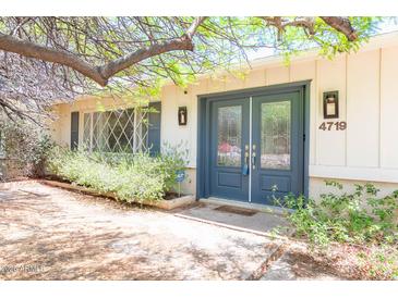 Charming home featuring a blue front door with glass panels and well-manicured landscaping at 4719 N 70Th St, Scottsdale, AZ 85251