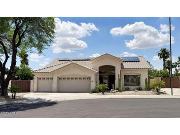 Charming single-story home with a three-car garage, desert landscaping, and solar panels at 20906 N 56Th Dr, Glendale, AZ 85308