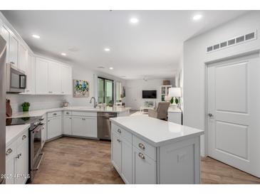Open-concept kitchen with white cabinetry, stainless steel appliances, and a central island at 2511 W Queen Creek Rd # 174, Chandler, AZ 85248