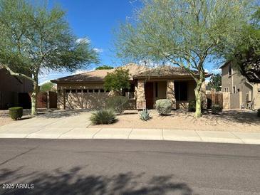 Charming single-story home featuring desert landscaping, a two-car garage, and a neutral color scheme at 26449 N 84Th Dr, Peoria, AZ 85383