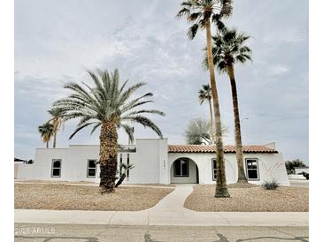 Charming single-story home featuring desert landscaping, palm trees, and a red tile roof at 6401 E Eugie Ter, Scottsdale, AZ 85254
