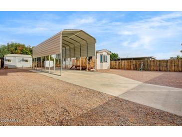 Manufactured home featuring a large carport, wood steps, and low maintenance landscaping at 853 S Evangeline Ave, Mesa, AZ 85208