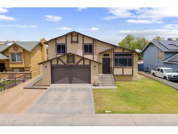 Inviting two-story home featuring a well-manicured lawn and a classic Tudor-style facade with a two-car garage at 8912 W Sheridan St, Phoenix, AZ 85037