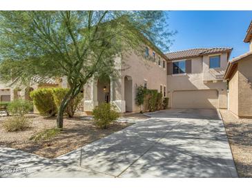 Two-story home features a well-maintained lawn, neutral-toned stucco, and a spacious driveway leading to the garage at 11906 N 154Th N Ln, Surprise, AZ 85379