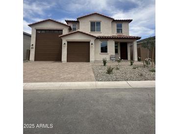 Inviting two-story home showcasing a stucco exterior, tiled roof, desert landscaping and a spacious two-car garage at 18692 E Helian Dr, Gold Canyon, AZ 85118