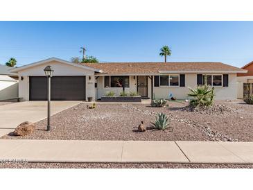 Charming single-story home featuring desert landscaping, a two-car garage, and a neutral color palette at 3010 E Yucca St, Phoenix, AZ 85028