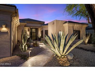 Inviting front exterior with desert landscaping and modern architectural details at twilight at 33667 N 71St Way, Scottsdale, AZ 85266