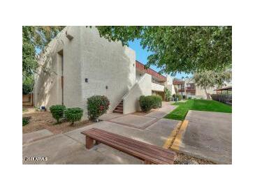 Cozy condo community featuring stucco exterior, staircase access, mature trees and a wooden bench at 3828 N 32Nd St # 213, Phoenix, AZ 85018