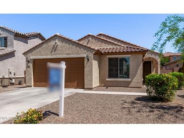 Charming single-story home with a tile roof, two-car garage, and low maintenance desert landscaping at 7086 W Spur Dr, Peoria, AZ 85383