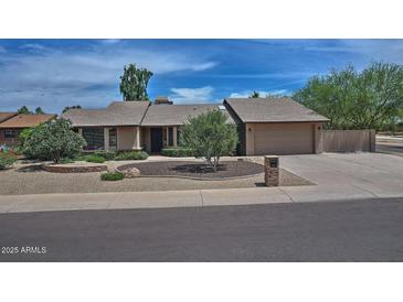 Charming single-story home with a two-car garage and low-maintenance desert landscaping at 9476 E Laurel Ln, Scottsdale, AZ 85260