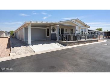 Charming single-story home with covered porch and attached carport, offering comfort and convenience at 2206 S Ellsworth Rd # 160B, Mesa, AZ 85209