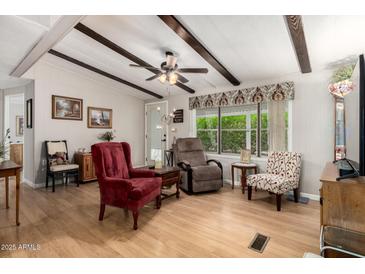 Cozy living room with wood floors, ceiling fan, beamed ceiling and comfortable seating at 8330 E Pueblo Ave, Mesa, AZ 85208