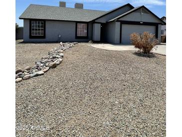 Charming single-story home featuring a low maintenance rock front yard and attached two car garage at 8703 W Golden Ln, Peoria, AZ 85345