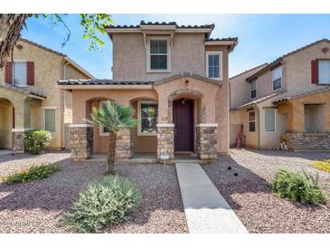 Charming two-story home featuring a covered entryway, a landscaped yard with decorative rock at 9 N 87Th N Ln, Tolleson, AZ 85353