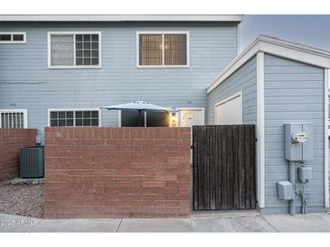Charming home featuring a brick wall and gate, creating a private entrance and curb appeal at 2301 E University Dr # 341, Mesa, AZ 85213