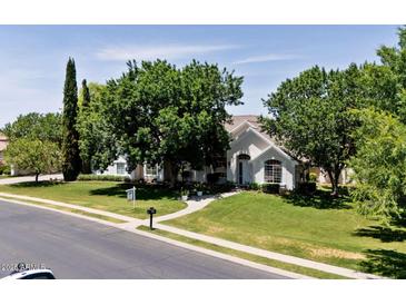 Charming single-story home with lush green lawn, mature trees, and inviting walkway at 3750 E Palm St, Mesa, AZ 85215