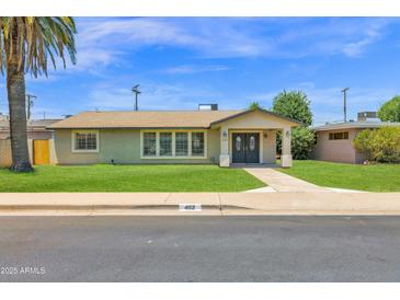 Charming single-story home featuring a well-maintained lawn, palm tree, and welcoming double-door entryway at 4112 N 4Th Ave, Phoenix, AZ 85013