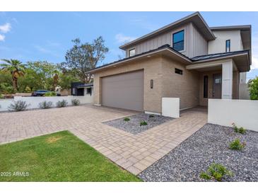 Modern two-story home featuring a brick facade, a two-car garage, and beautifully landscaped front yard at 5537 E Earll Dr, Phoenix, AZ 85018