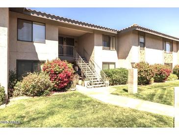 Inviting two-story condo with well-maintained landscaping and stair access to upper units at 1402 E Guadalupe Rd # 215, Tempe, AZ 85283